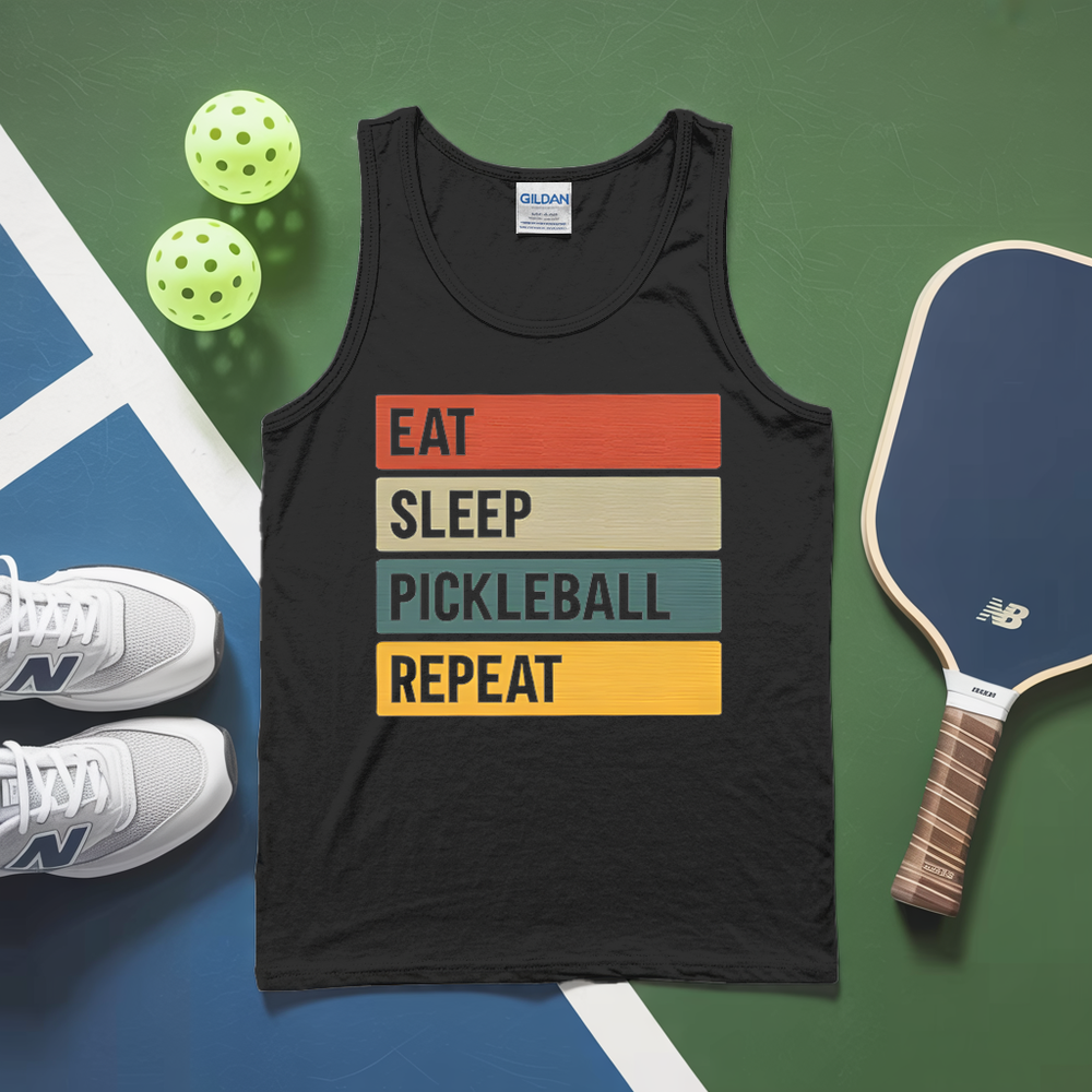 Black tank top with 'Eat Sleep Pickleball Repeat' text, pickleball paddle, balls, and shoes on a green and blue surface.