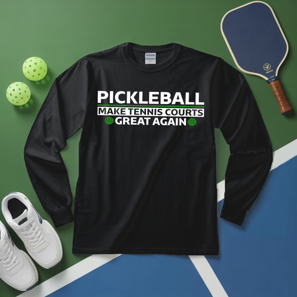 Black long-sleeve shirt with pickleball text on a green and blue surface with pickleball equipment.