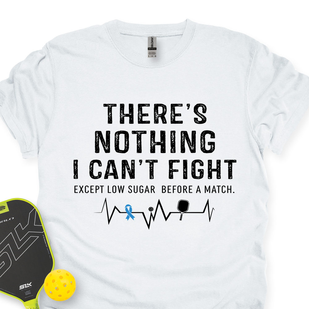 White t-shirt with humorous text design and pickleball paddle and ball on a white background