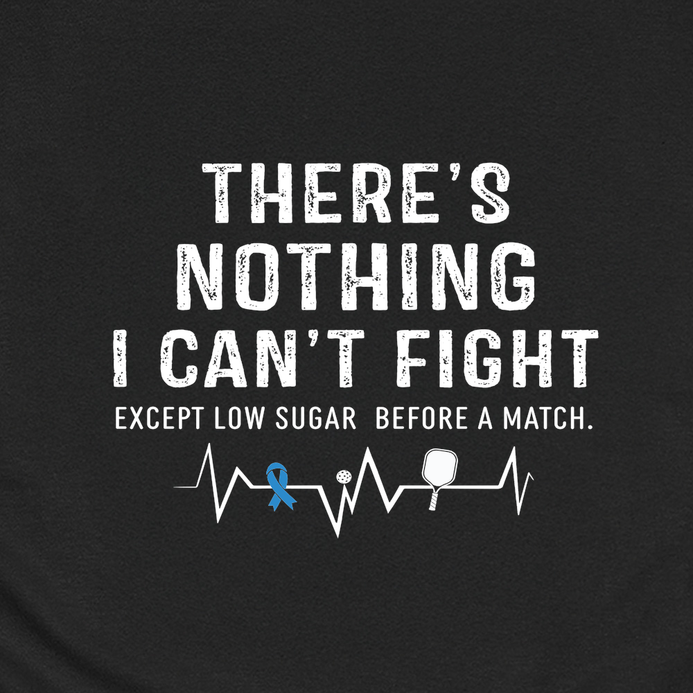 Black t-shirt with motivational quote and pickleball accessories on a white background