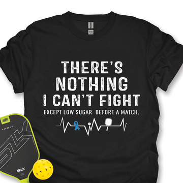 Black t-shirt with motivational quote and pickleball accessories on a white background