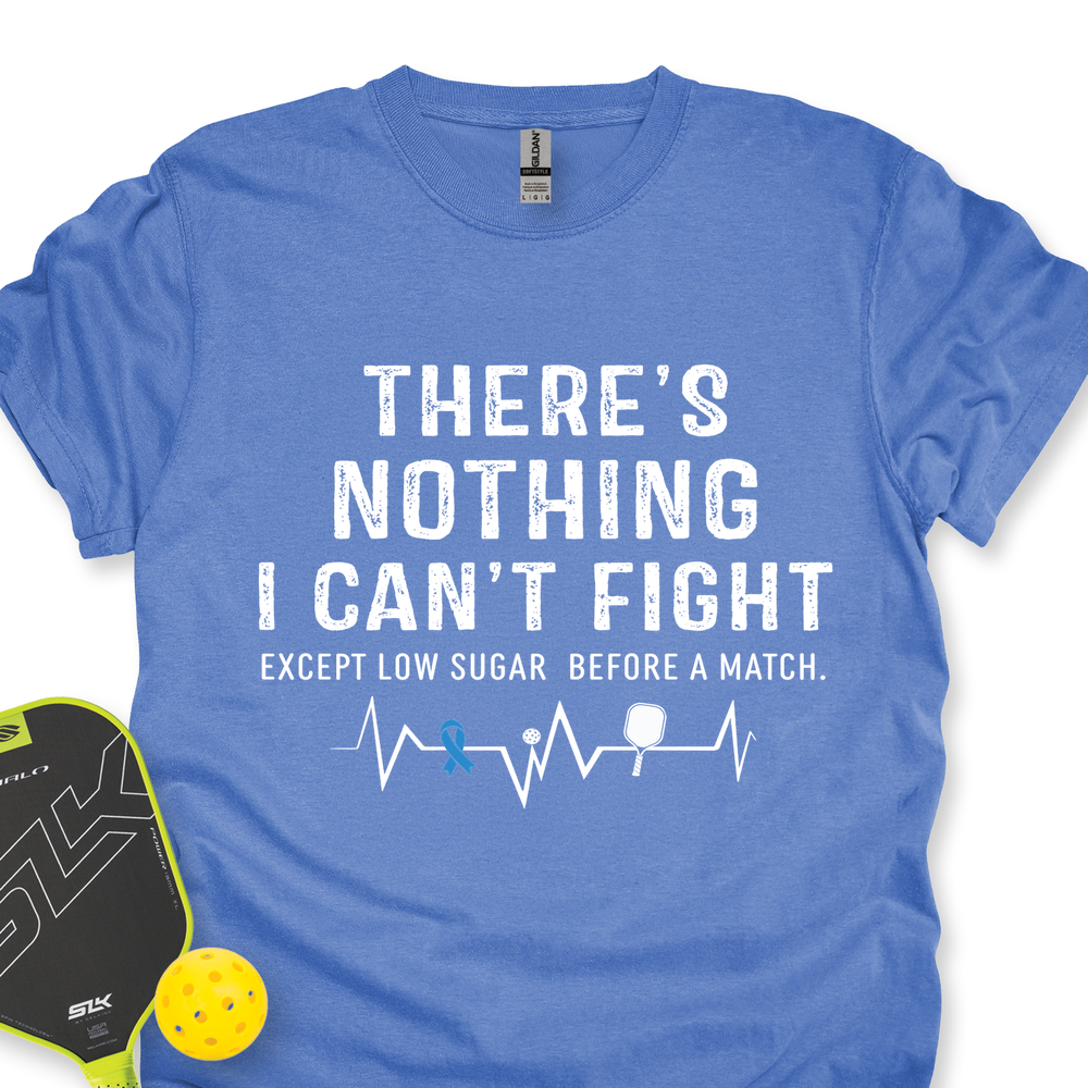 Blue t-shirt with motivational quote and pickleball items on a white background