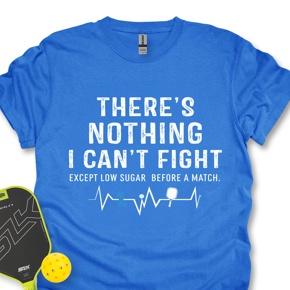 Blue t-shirt with white text and pickleball accessories on a white background