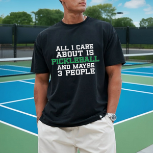 Person wearing a black t-shirt with pickleball text on a tennis court