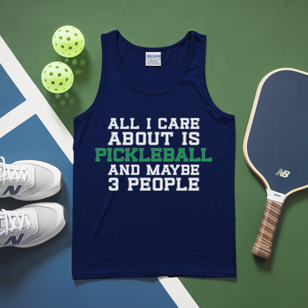 Navy tank top with pickleball text on a green and blue surface with pickleballs and a paddle.