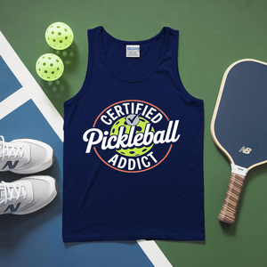 Navy tank top with 'Certified Pickleball Addict' text, pickleballs, and paddle on a green and blue surface.
