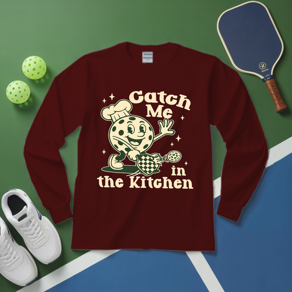 Maroon long-sleeve shirt with a graphic design on a green and blue surface with sports equipment.