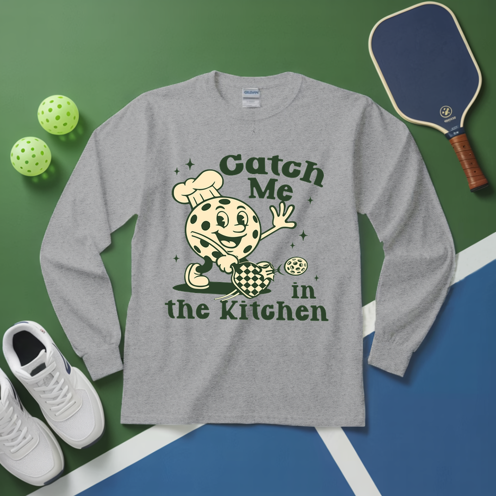 Gray long-sleeve shirt with a graphic design and pickleball equipment on a green and blue background