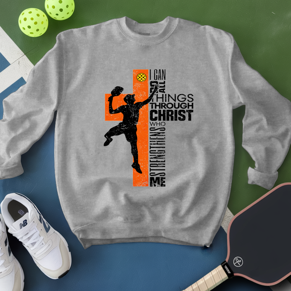 Gray sweatshirt with a graphic design featuring a silhouette of a person and text, placed on a green and blue surface with sports equipment.