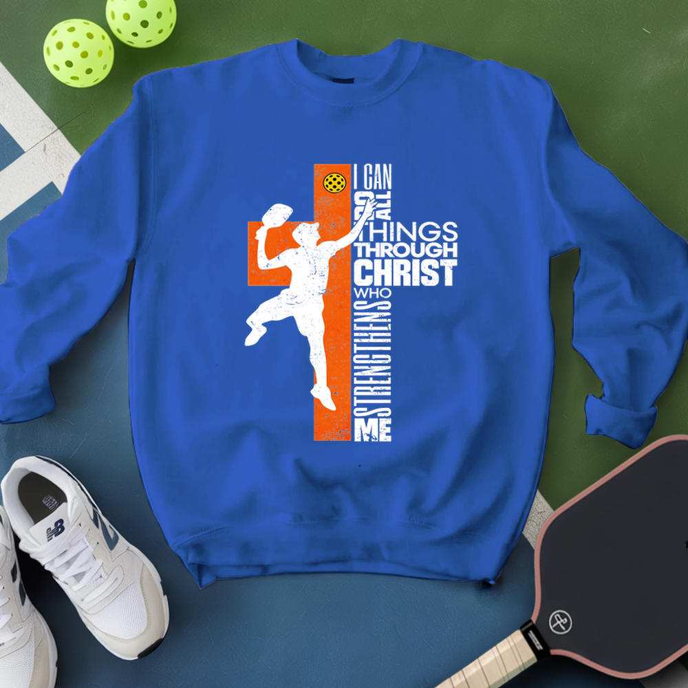 Blue sweatshirt with a graphic design on a green surface with sports equipment.