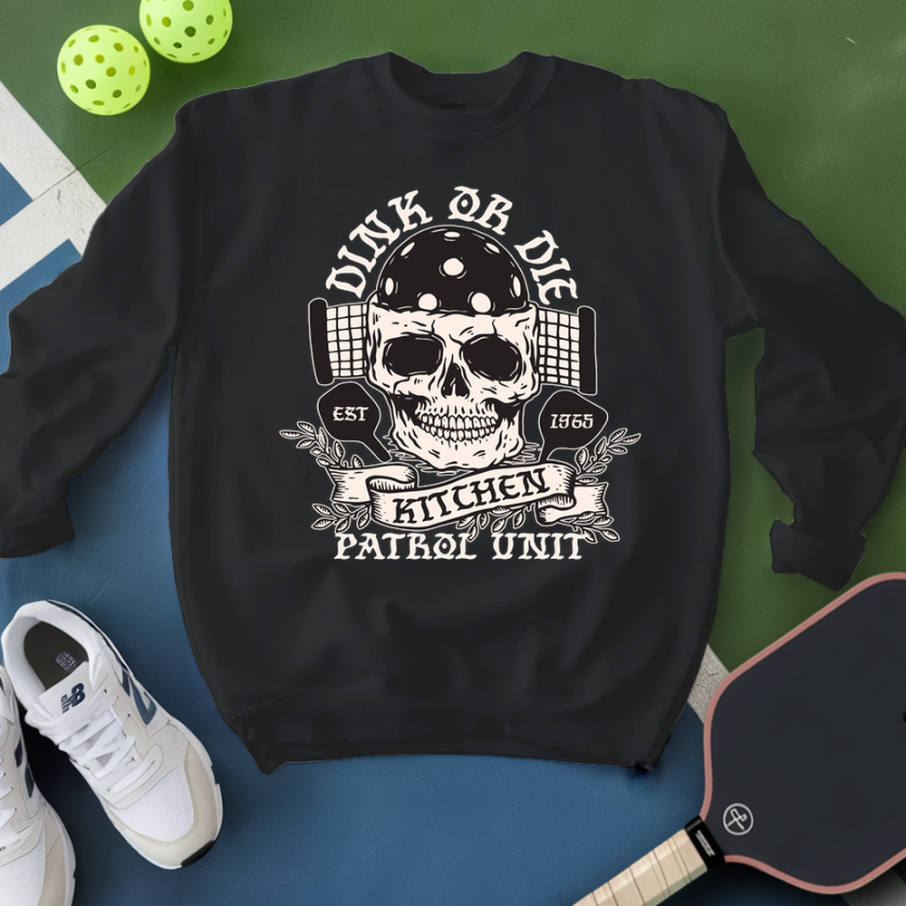 Black sweatshirt with skull design and text, placed on a blue surface with sports equipment.
