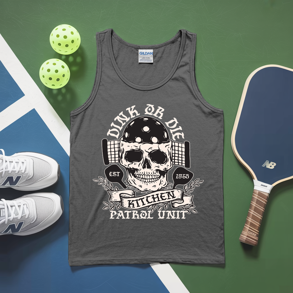 Gray tank top with skull design and text, placed on a green and blue surface with pickleballs and a paddle.