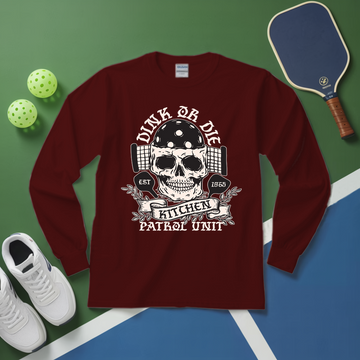 Maroon long-sleeve shirt with skull design on a green and blue surface with sports equipment.