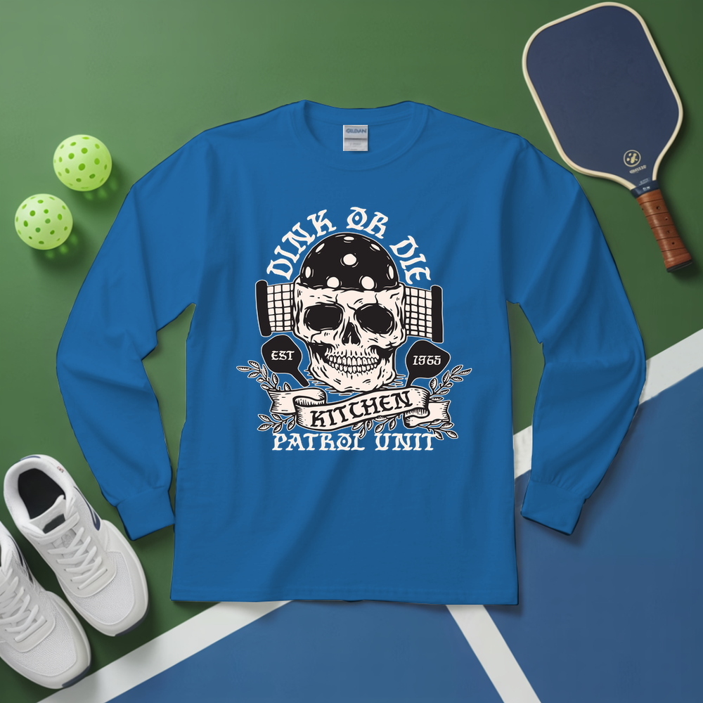 Blue long-sleeve shirt with skull graphic and text on a green and blue surface with sports equipment.