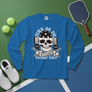 Blue long-sleeve shirt with skull graphic and text on a green and blue surface with sports equipment.