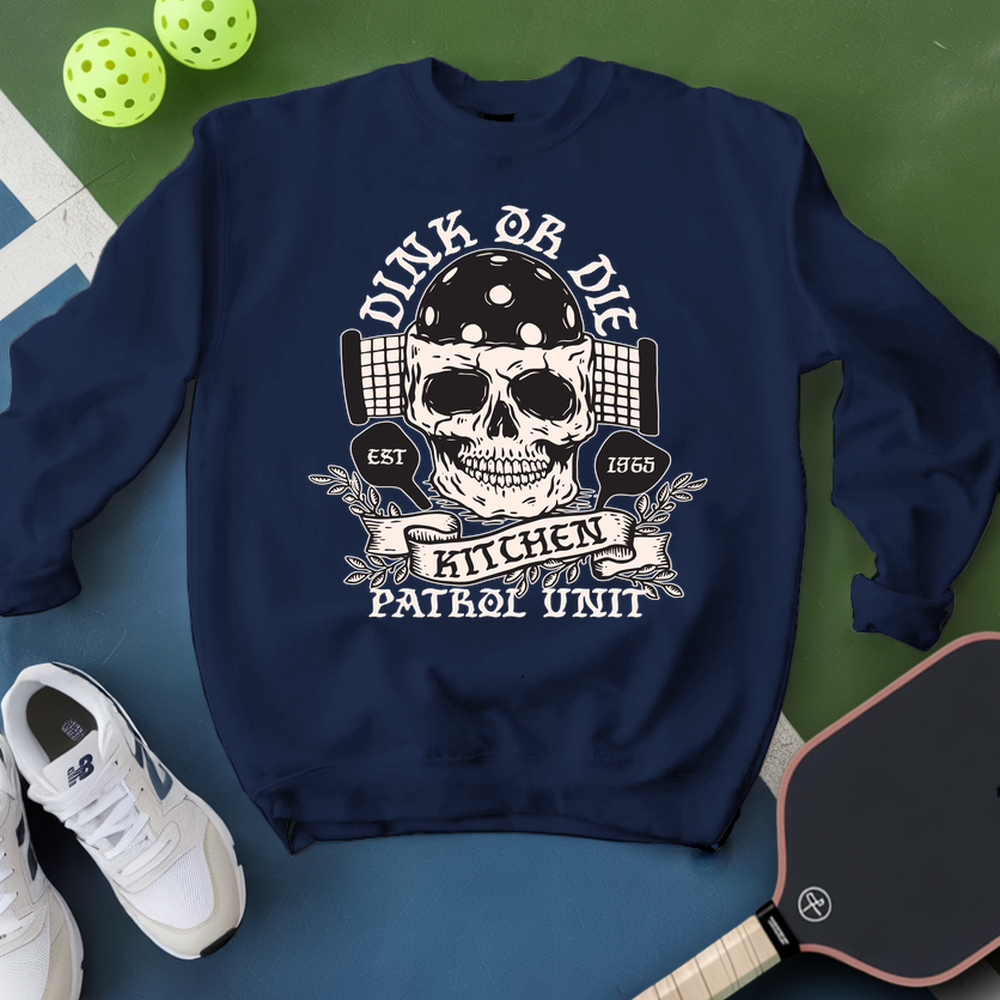 Navy blue sweatshirt with skull design and text, placed on a green and blue surface with sports equipment.