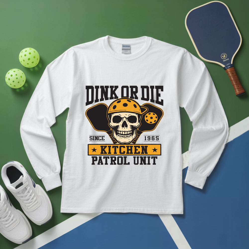 White long-sleeve shirt with skull graphic and text on a green and blue background with pickleball equipment.