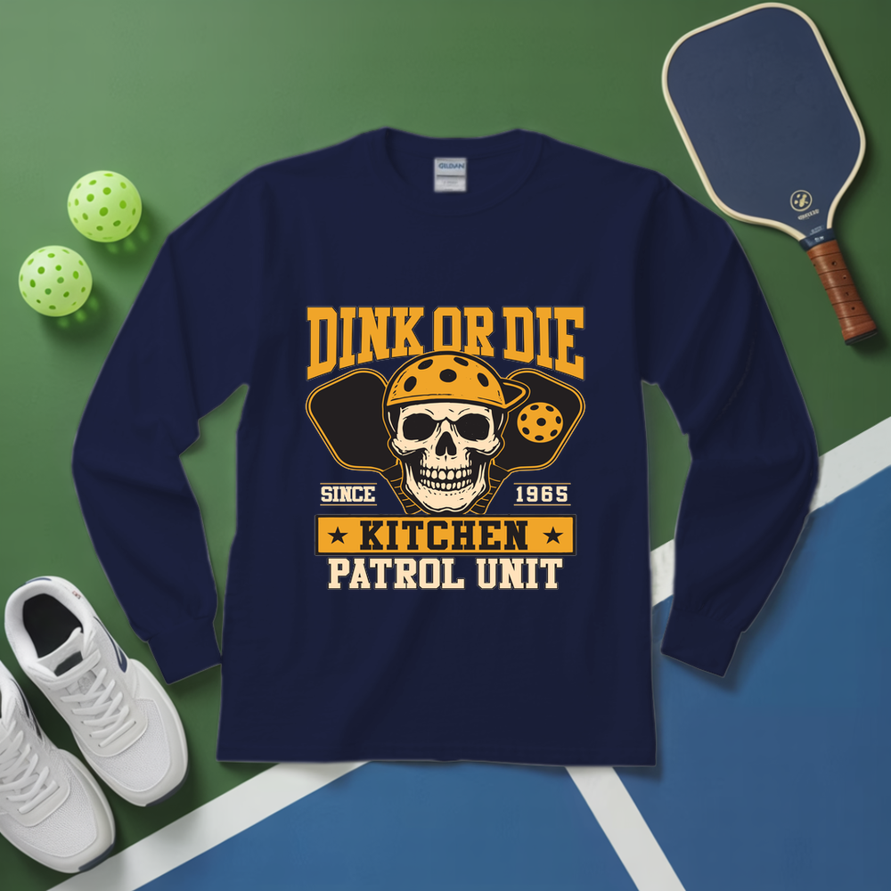 Navy blue long-sleeve shirt with skull and paddle graphic on a green and blue background with pickleball equipment.