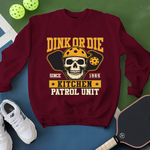 Maroon sweatshirt with skull graphic and text on a green and blue background