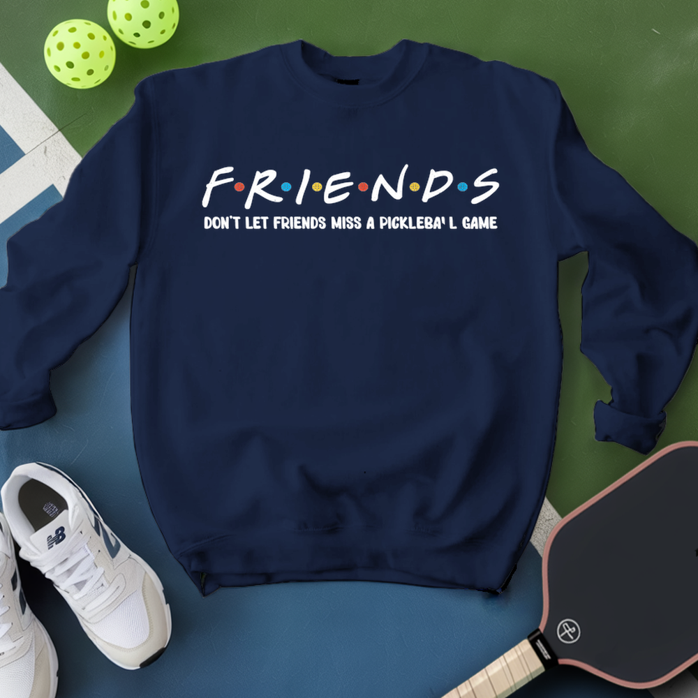 Navy blue sweatshirt with 'FRIENDS' text, white sneakers, and pickleball equipment on a green and blue surface.