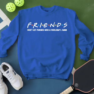 Blue sweatshirt with 'FRIENDS' text, white sneakers, and pickleball paddle on a green surface
