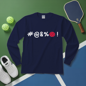 Navy blue long-sleeve shirt with '#@&%' text and pickleball ball design on a green and blue surface with sports equipment.