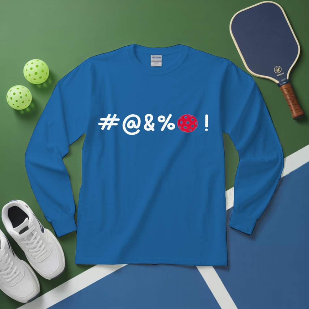 Blue long-sleeve shirt with '#@&%' text, pickleball paddle, balls, and shoes on a green and blue surface.
