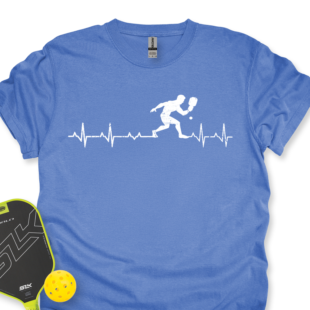 Blue t-shirt with pickleball player design and paddle and ball on a white background
