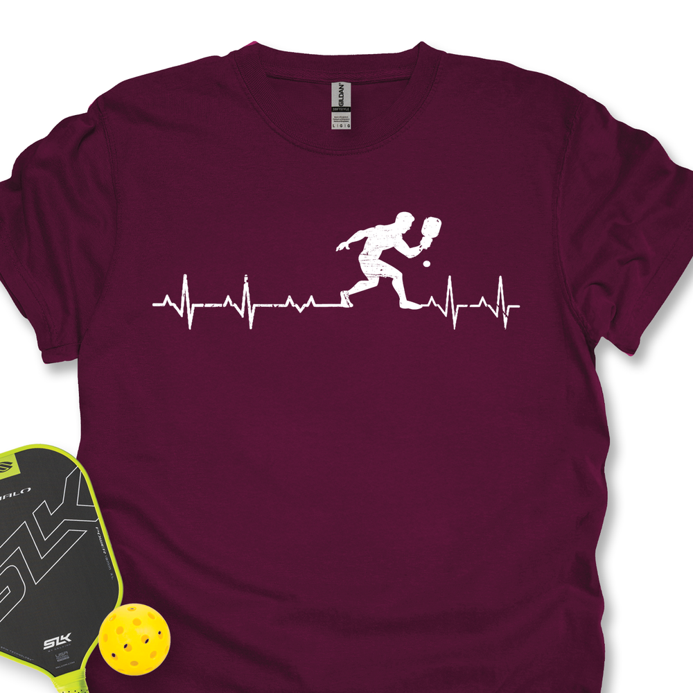 Maroon t-shirt with pickleball design and paddle and ball on a white background