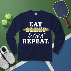 Navy blue sweatshirt with 'Eat Sleep Dink Repeat' text on a green and blue background with pickleball equipment.