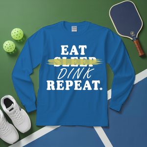 Blue long-sleeve shirt with 'Eat Sleep Dink Repeat' text on a green and blue sports court background.