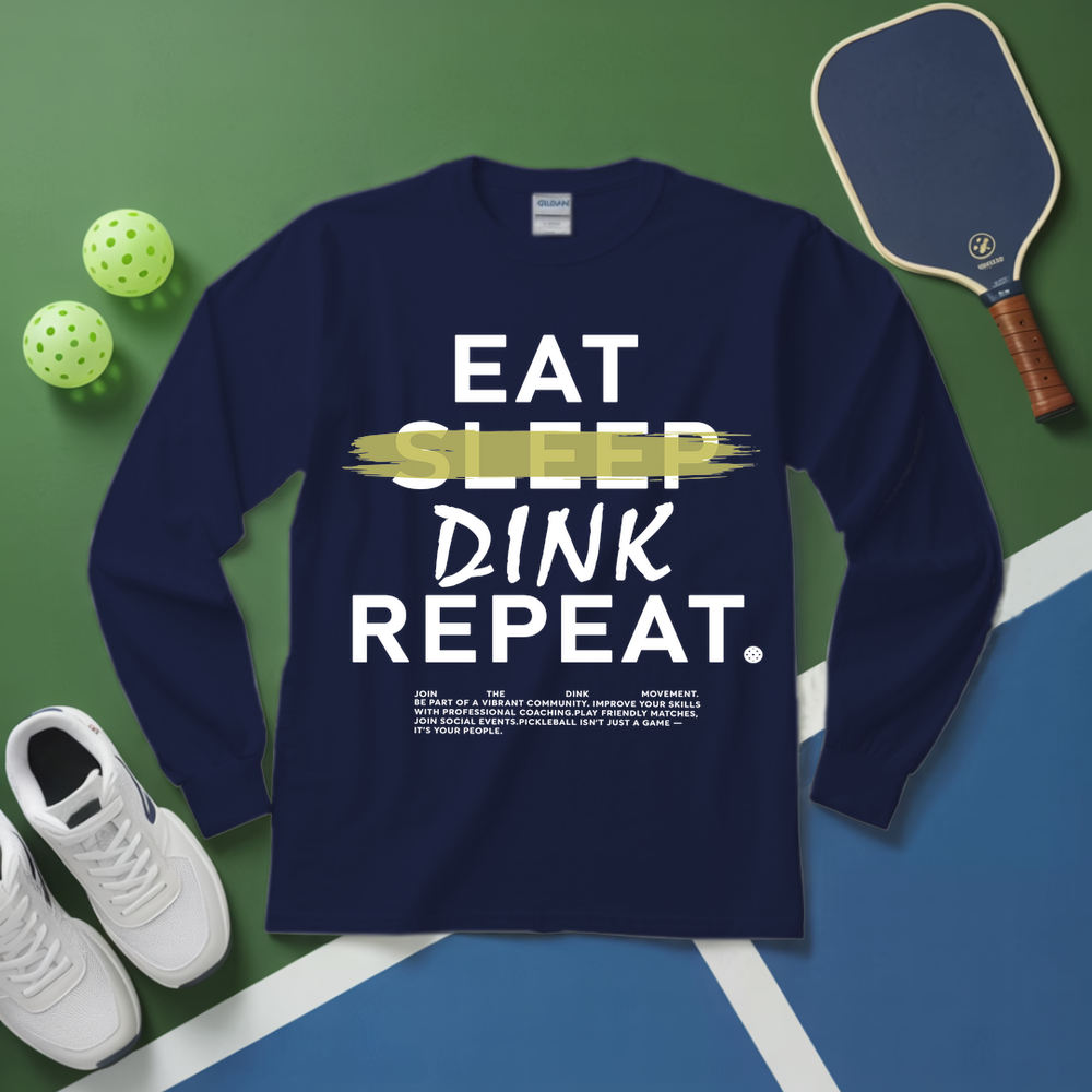 Navy blue long-sleeve shirt with 'Eat Sleep Dink Repeat' text on a green and blue surface with pickleball equipment.