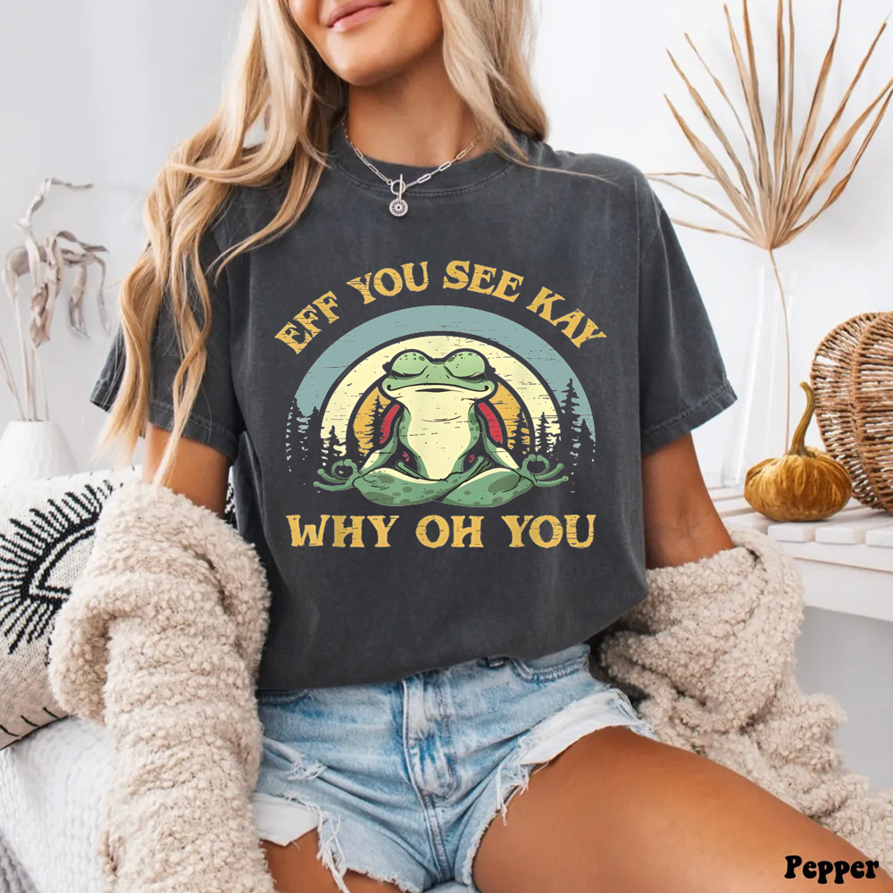 Person wearing a t-shirt with a graphic design and text, sitting indoors.