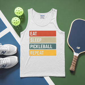 White tank top with 'Eat Sleep Pickleball Repeat' text, pickleballs, and a paddle on a green and blue background.