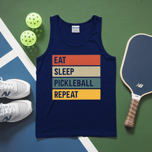 Navy tank top with 'Eat Sleep Pickleball Repeat' text on a green and blue surface with pickleballs and a paddle.