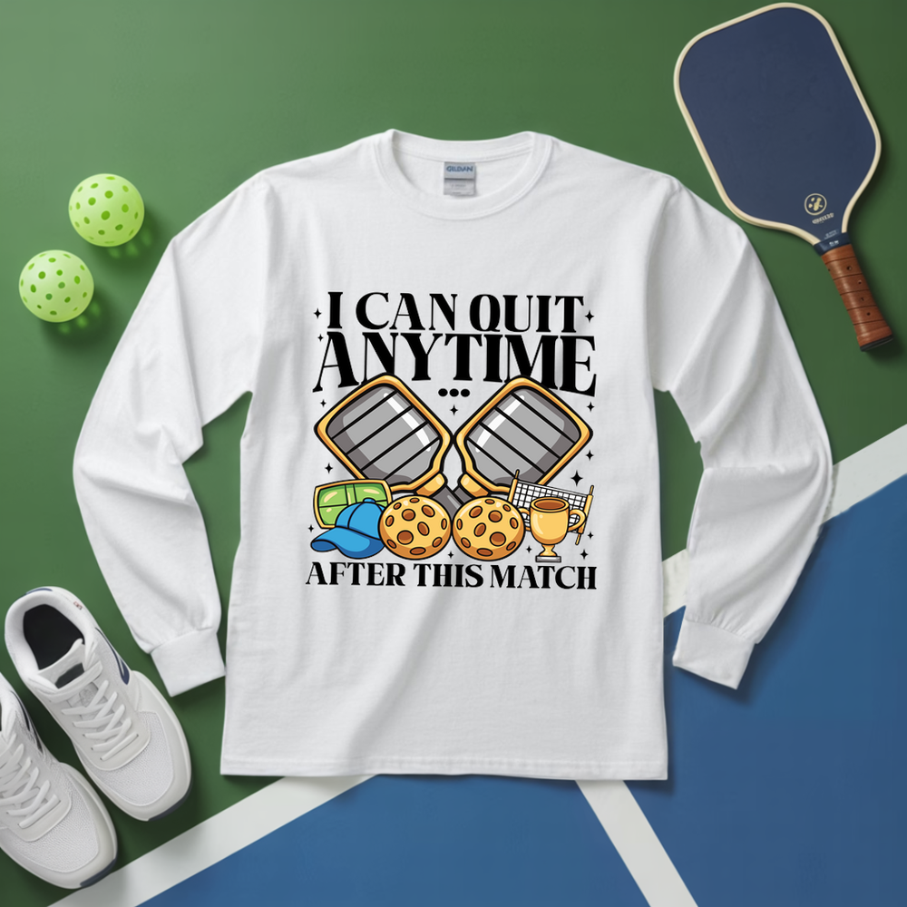 White long-sleeve shirt with pickleball-themed design on a green and blue background with pickleballs and a paddle.