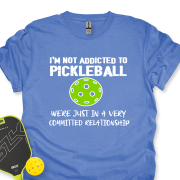 Blue t-shirt with pickleball-themed text and graphics on a white background