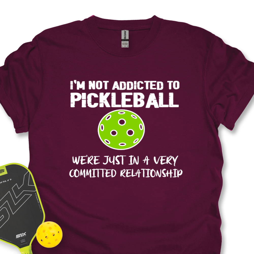 Maroon t-shirt with pickleball-themed text and graphics on a white background