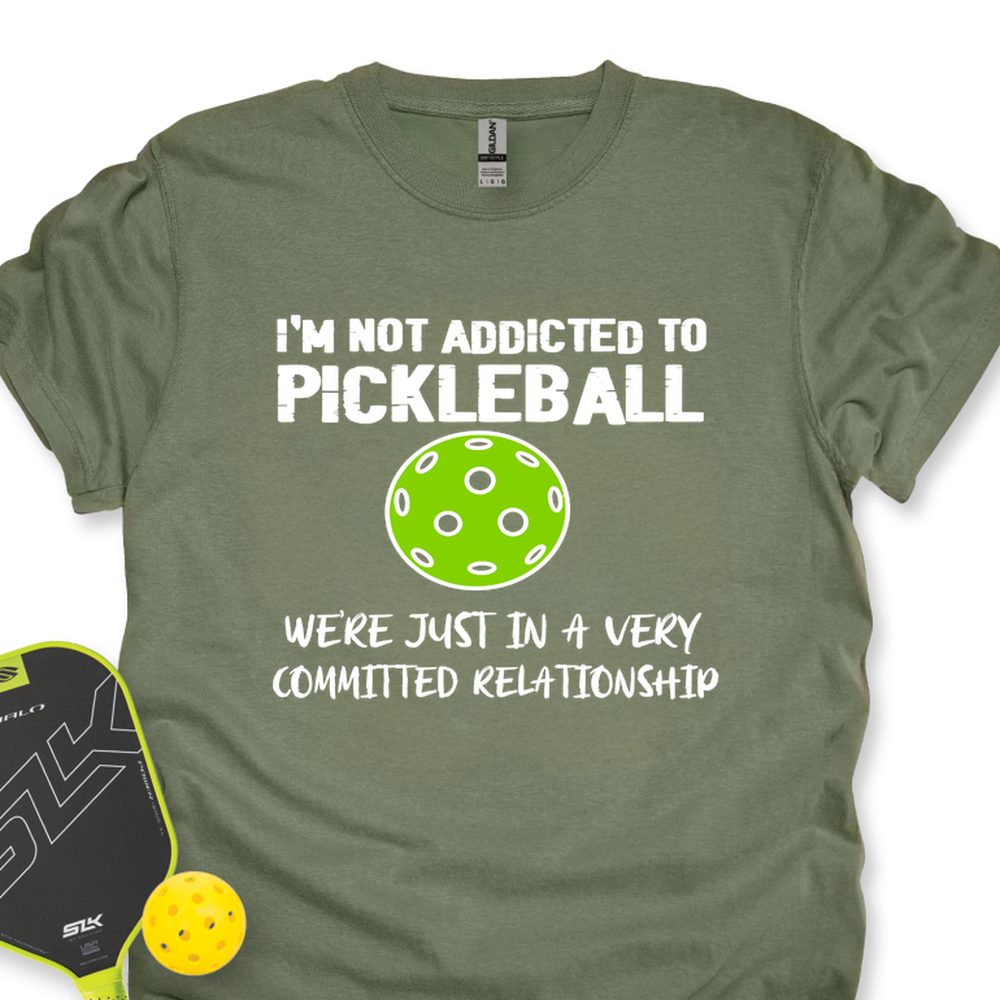 Green t-shirt with pickleball-themed text and graphics on a white background