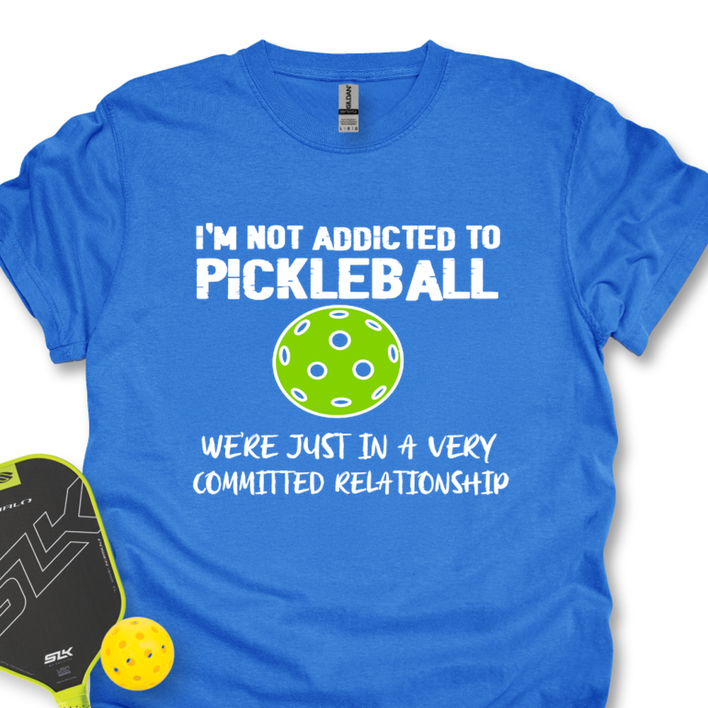 Blue t-shirt with pickleball-themed text and graphics on a white background