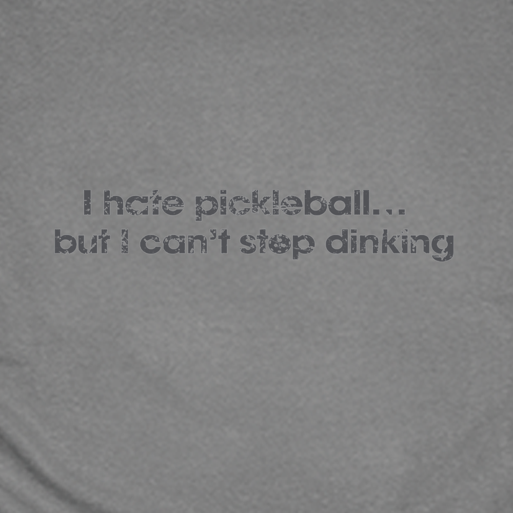 Gray t-shirt with humorous pickleball text, next to a pickleball paddle and ball on a white background