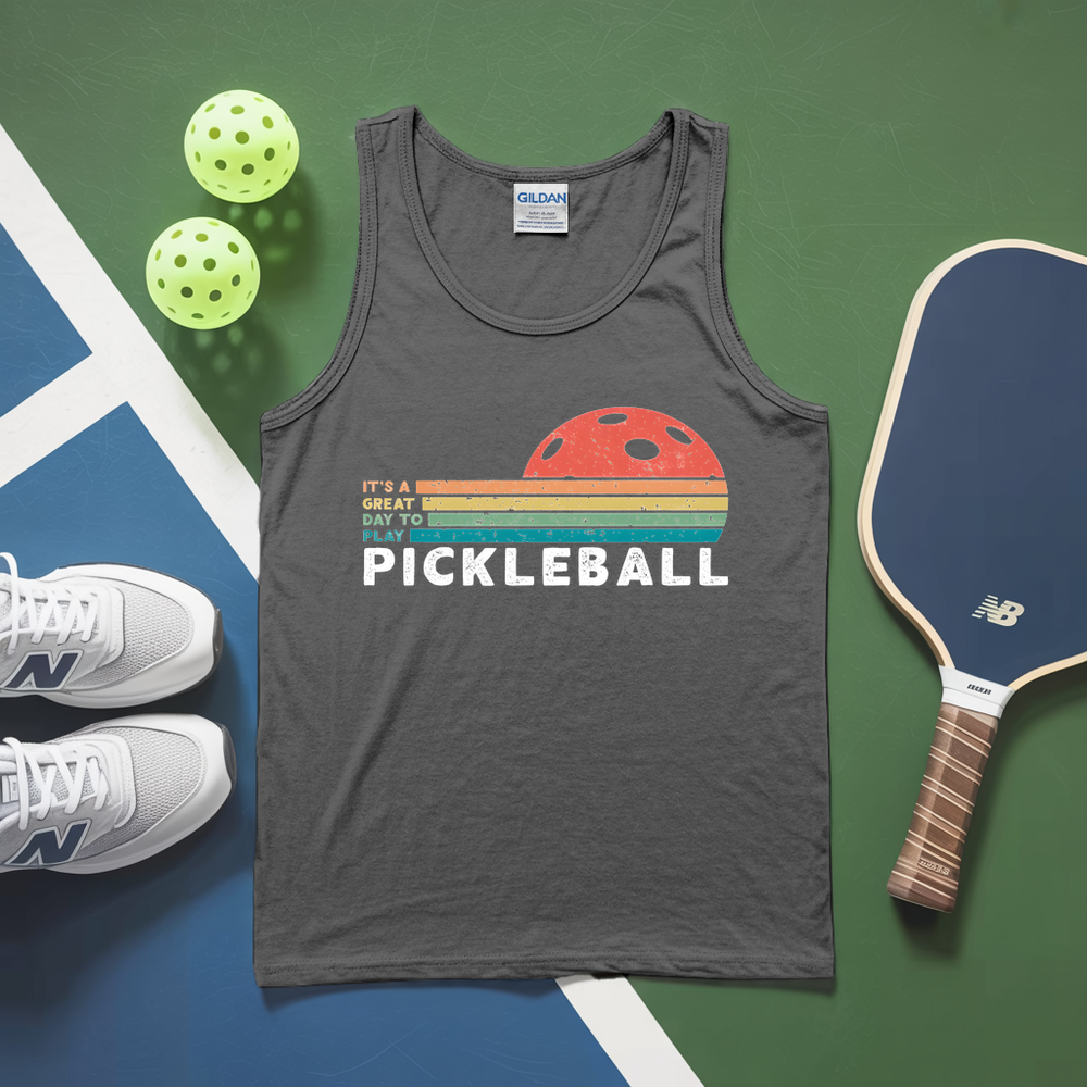 Gray tank top with pickleball design, pickleballs, and paddle on a green and blue surface