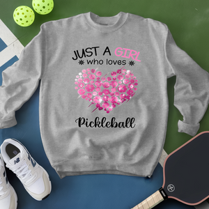Gray sweatshirt with pink heart and text about pickleball on a green and blue background.
