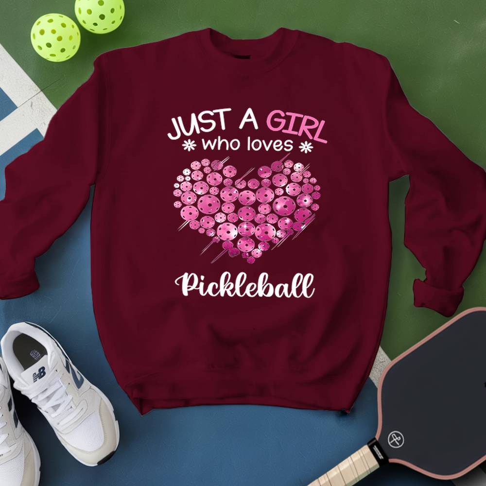 Maroon sweatshirt with pink heart and text 'Just a girl who loves Pickleball' on a green and blue background.