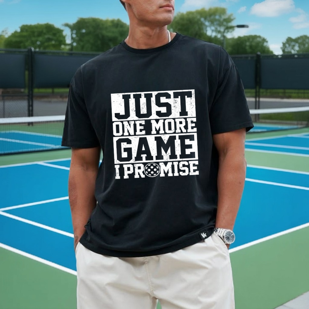 Person wearing a black t-shirt with text on a tennis court