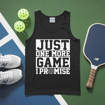 Black tank top with 'Just One More Game I Promise' text, pickleball paddles, and balls on a green and blue surface.