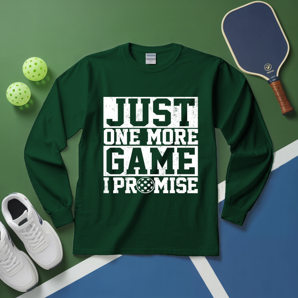 Green long-sleeve shirt with 'Just One More Game I Promise' text on a sports court background.
