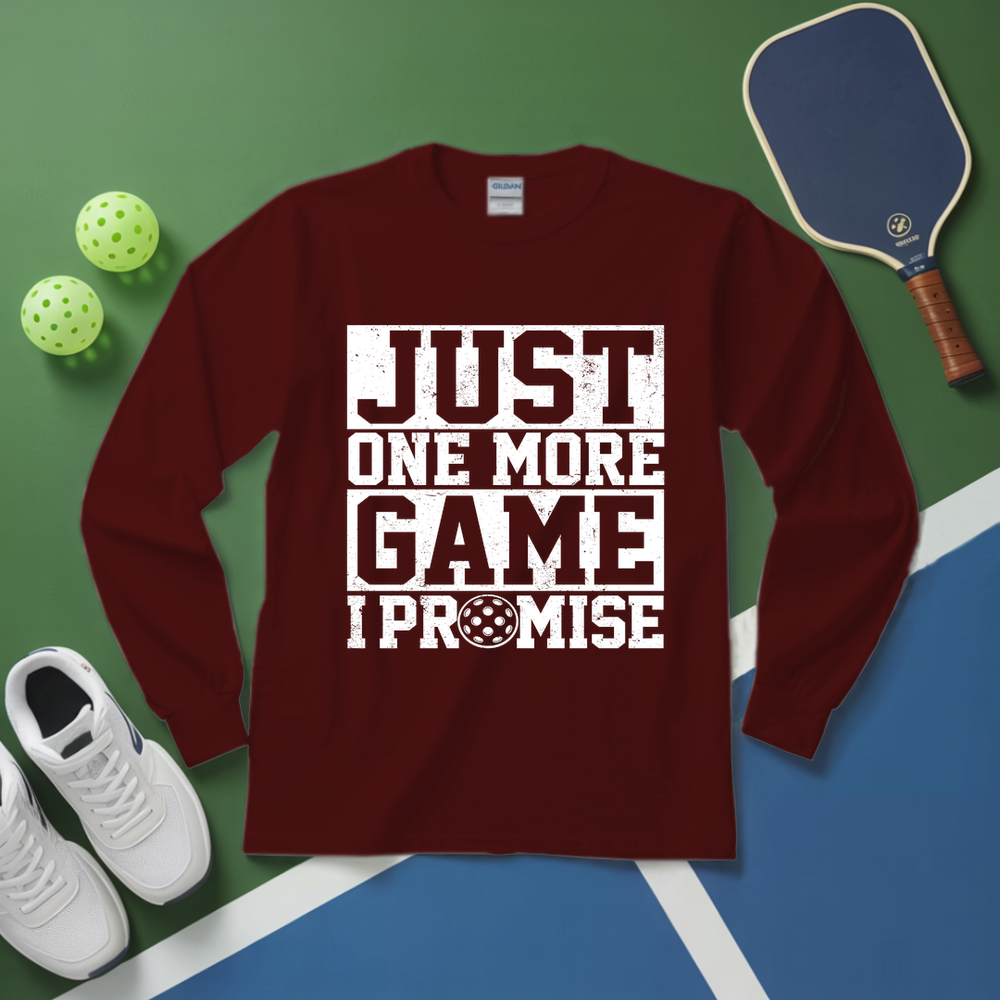 Maroon long-sleeve shirt with 'Just One More Game I Promise' text on a pickleball court background.