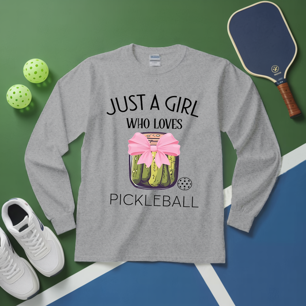 Gray long-sleeve shirt with pickleball design and text, surrounded by pickleball equipment on a green and blue background.
