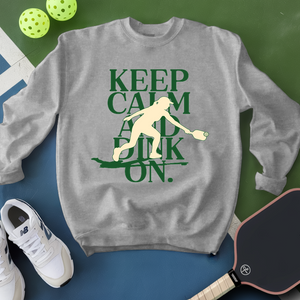 Gray sweatshirt with pickleball-themed design on a green and blue background